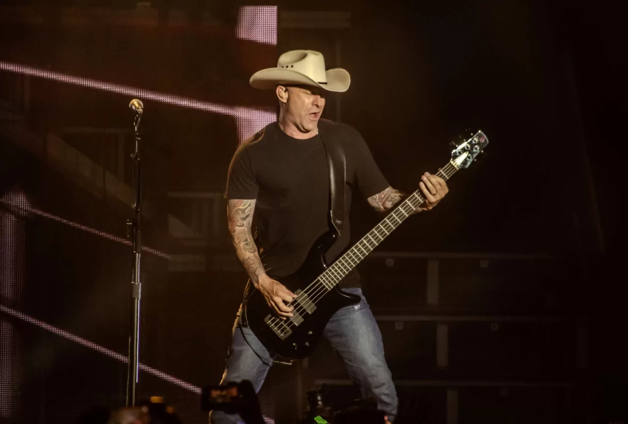 Mike Kroeger playing bass with Nickelback in an archive concert photograph