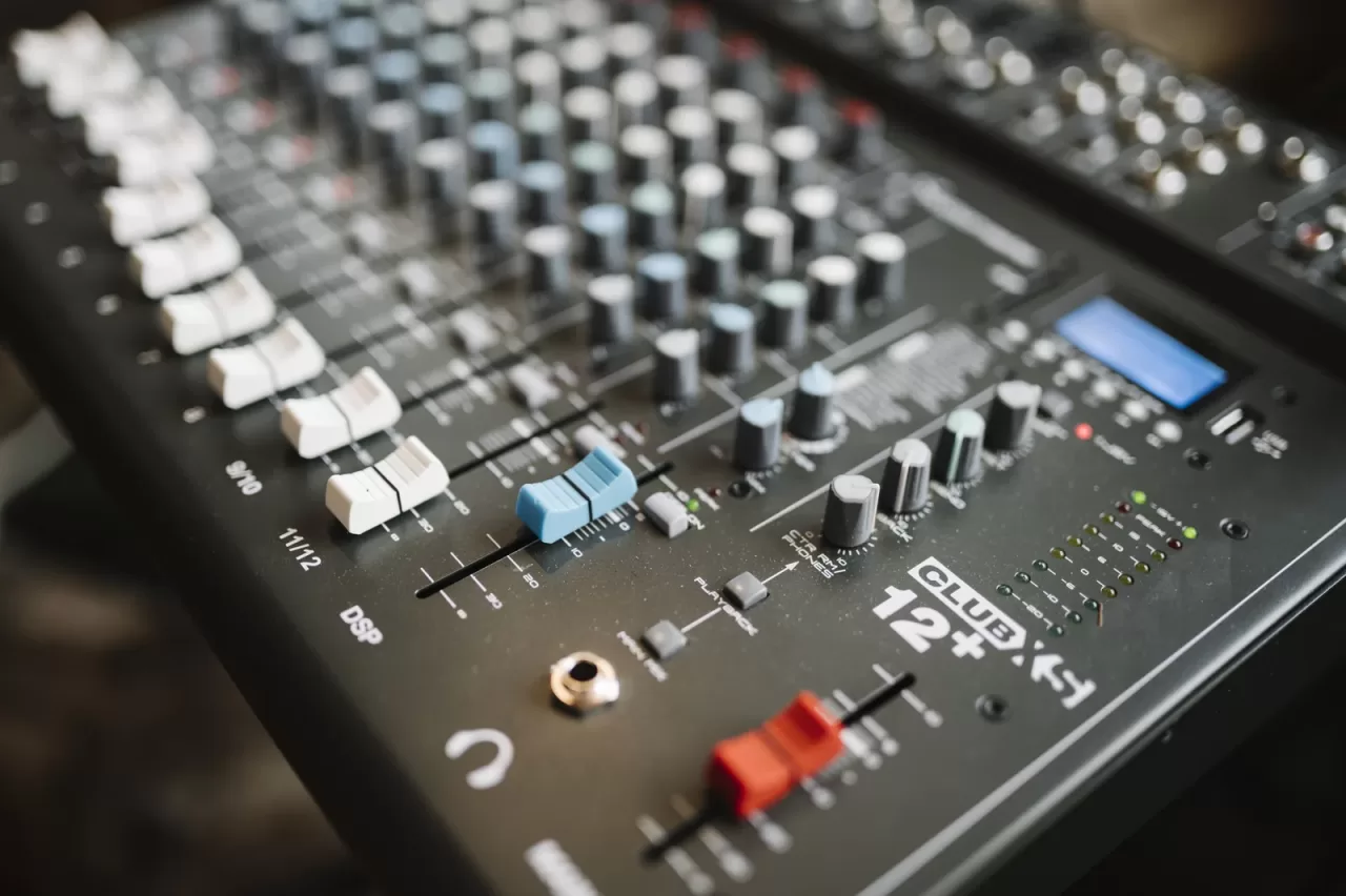A real recording-studio mixing console with rows of faders and controls.
