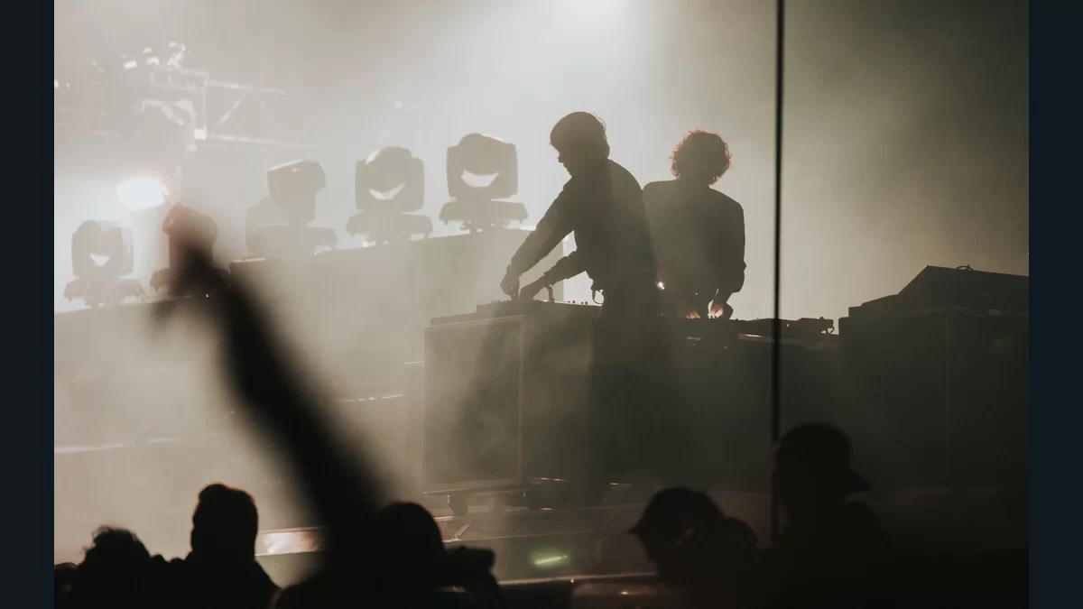Justice performing behind electronic equipment on stage in 2017