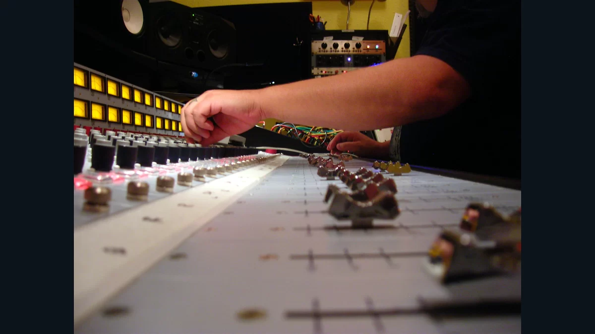 Hands working at the mixing console in Jackpot Recording Studio in Portland