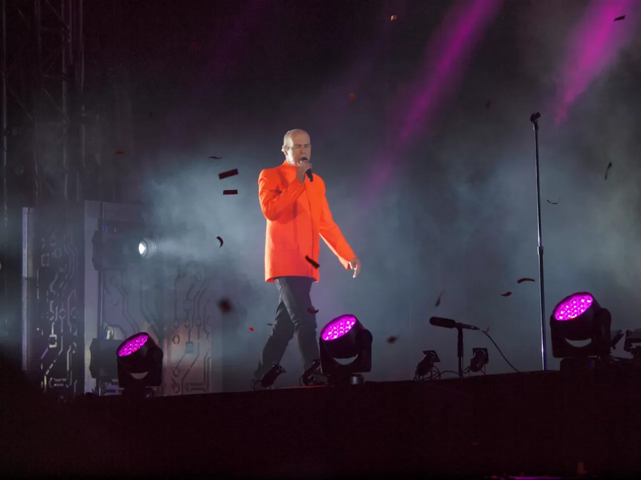 Neil Tennant of Pet Shop Boys singing in an orange jacket at Pori Jazz in 2014.