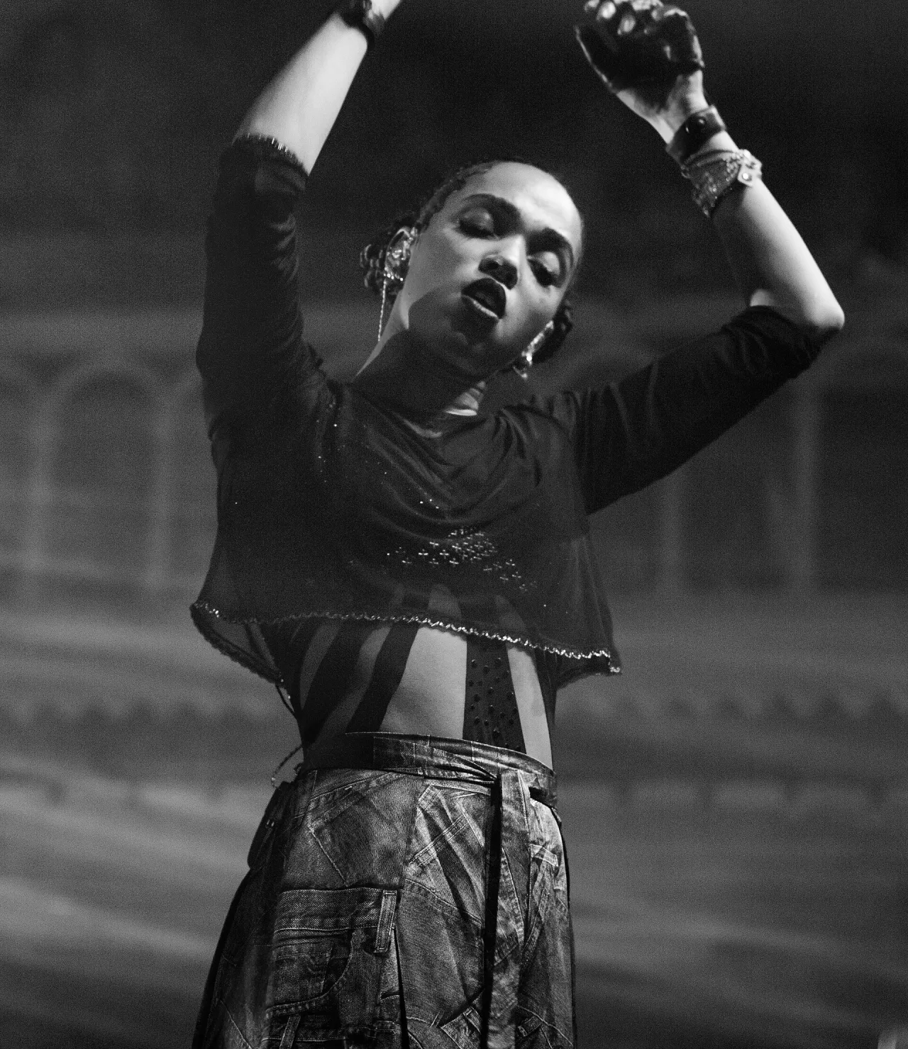 FKA twigs performing with her arms raised at Paradiso in 2015