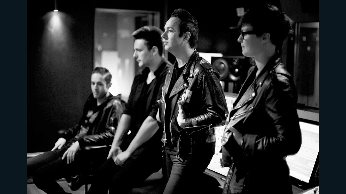 Black-and-white archive photograph of the four members of Glasvegas in a studio